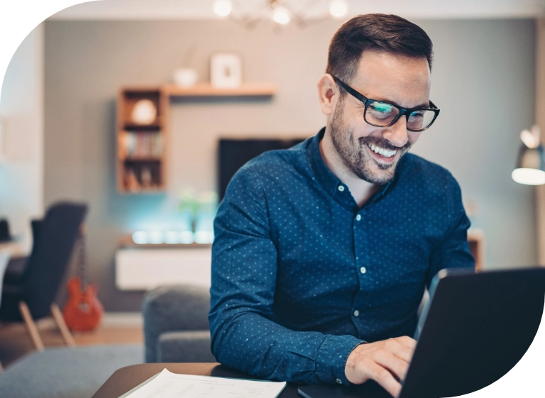 uśmiechnięty mężczyzna przed laptopem